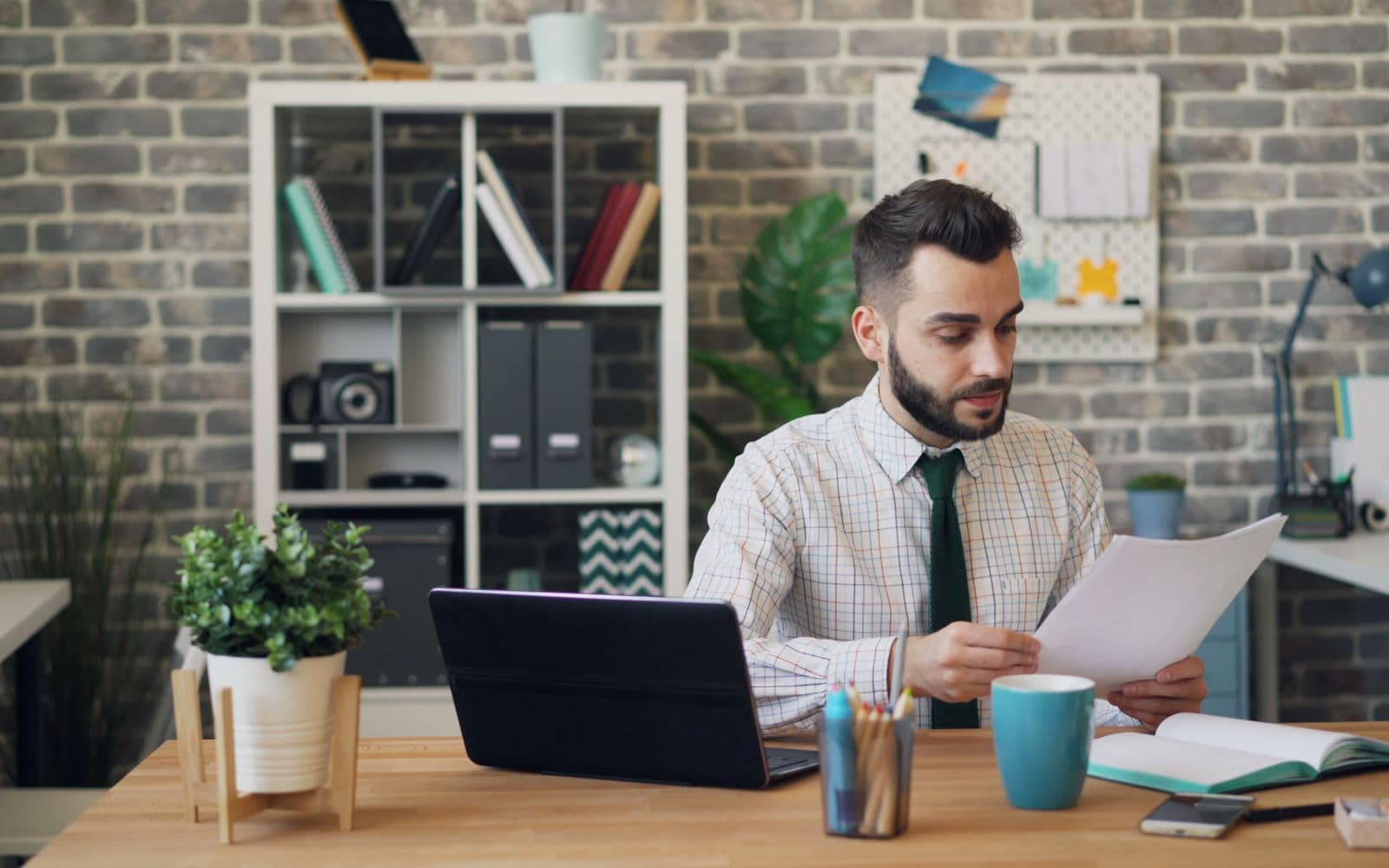 A business owner at their desk, reading what came back against the brief they posted